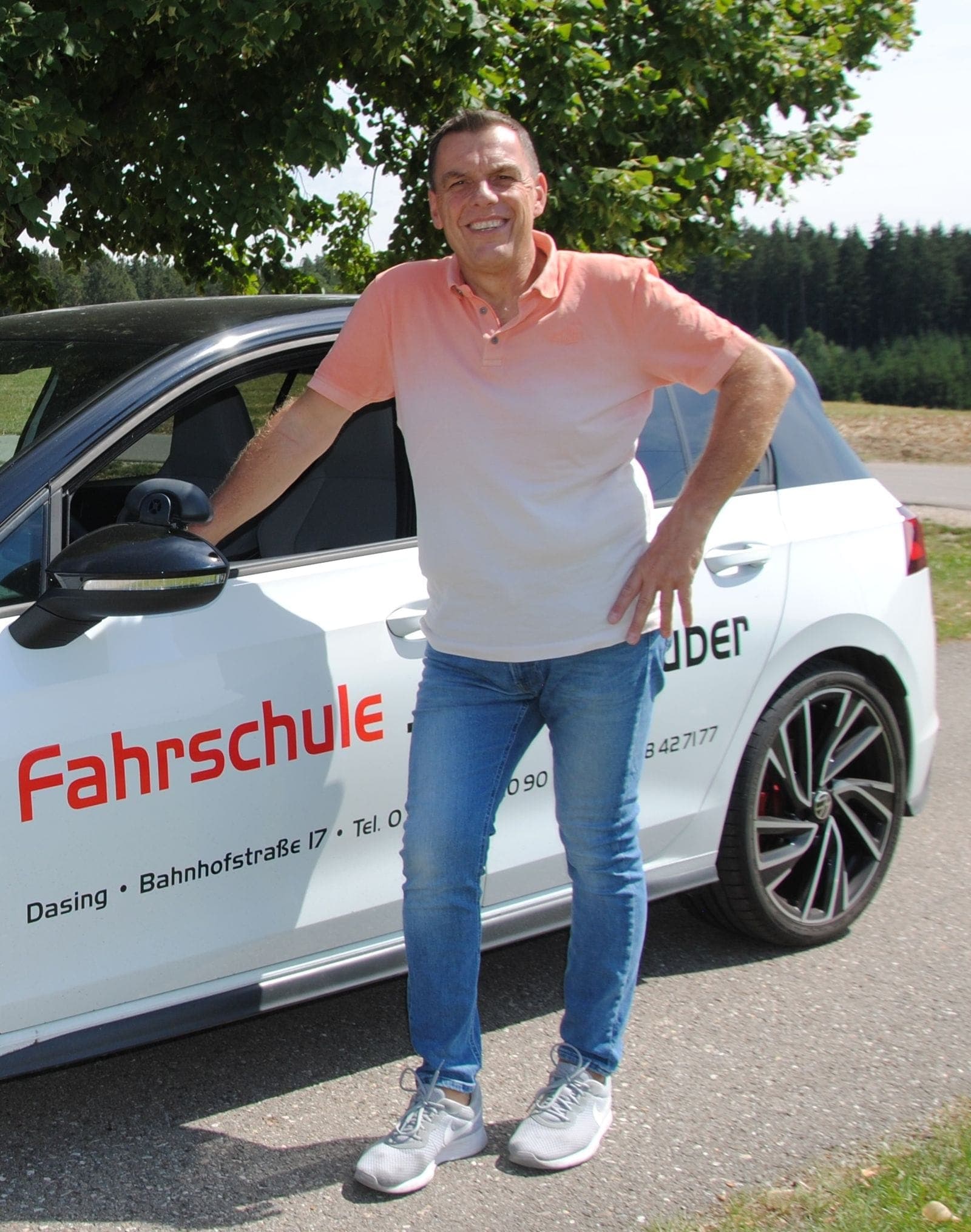 Fahrlehrer Jürgen Gruber am beschrifteten Fahrschulauto